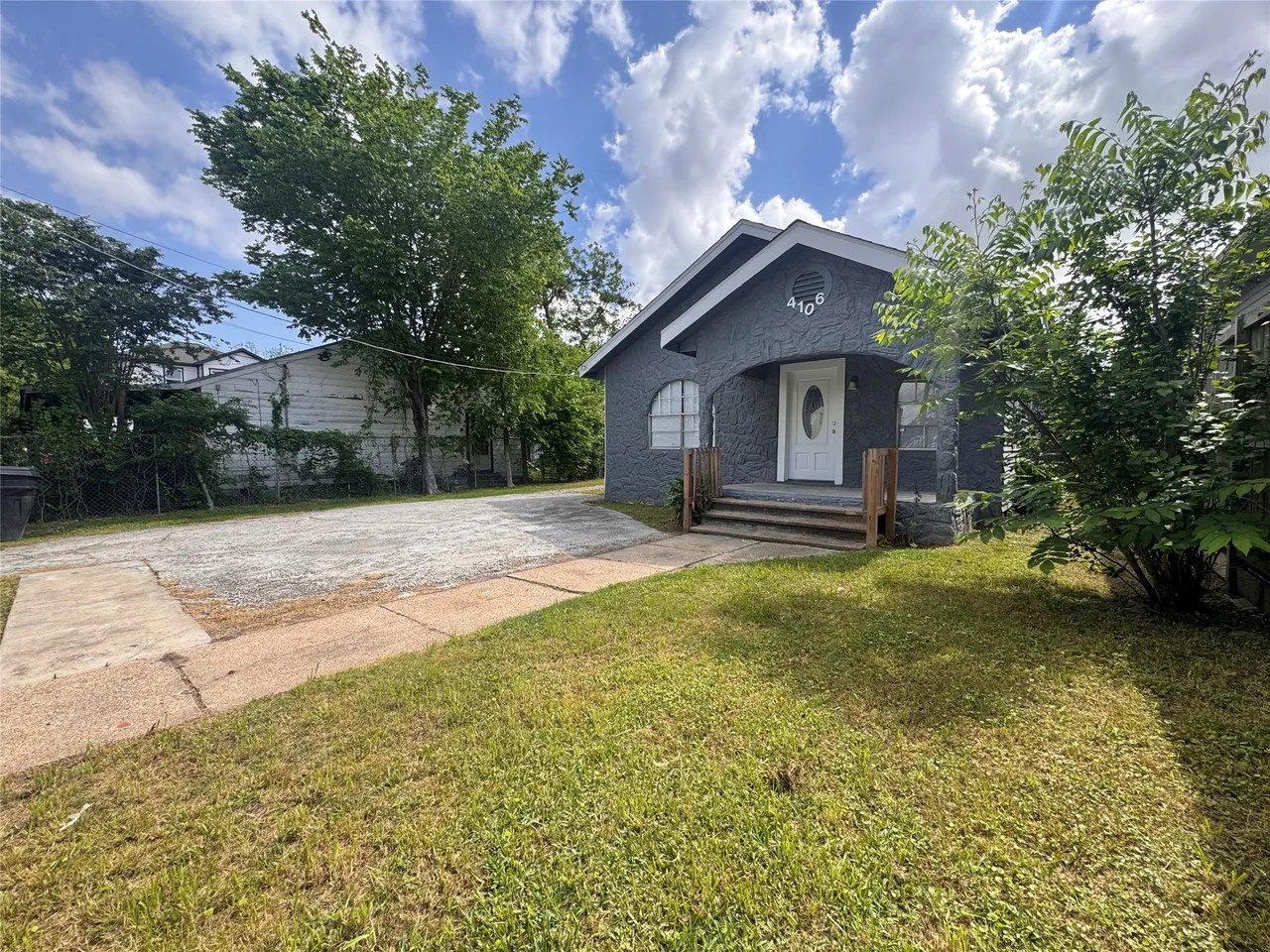 Front exterior of 4106 Robertson St — single-story home with arched entry, gable roof, and front lawn