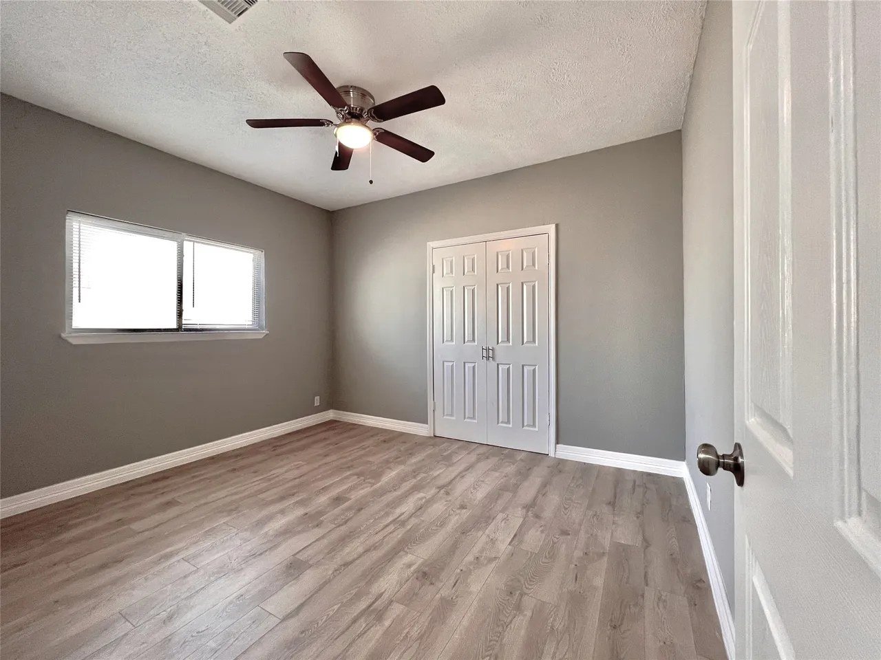 Bedroom with double-door closet, ceiling fan, and natural light