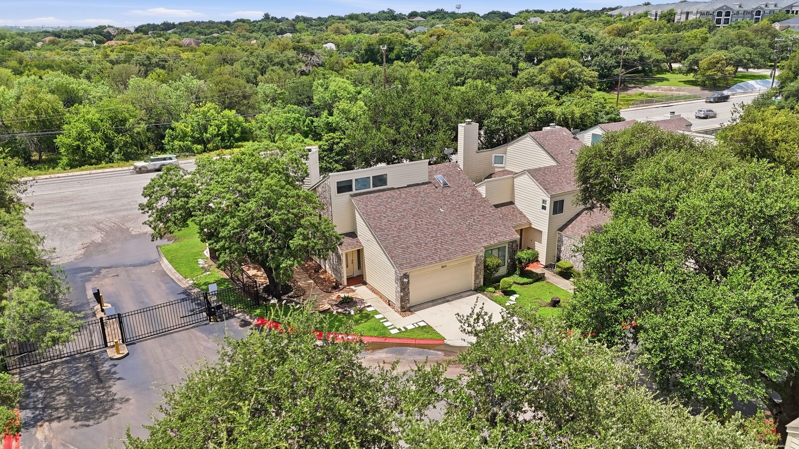 Aerial view of the gated community entrance and the home from the street