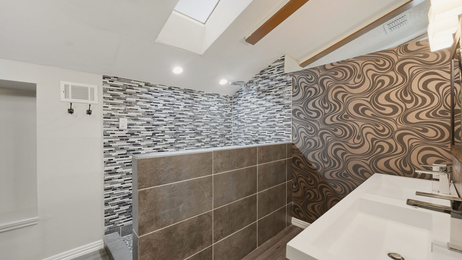 Staircase and entry nook with subway-tile accent wall near the kitchen